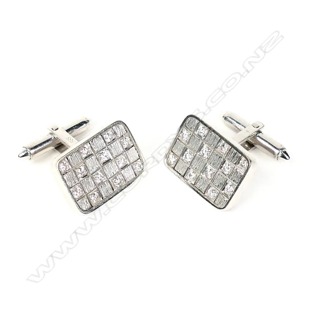 A pair of diamond set 14ct white gold panel cufflinks, each of oblong set with a checkerboard of 12 round brilliant cut diamonds on hinged bar backs. The 24 diamonds of approx. TDW 1.20ct. Valuation available. Image 1++