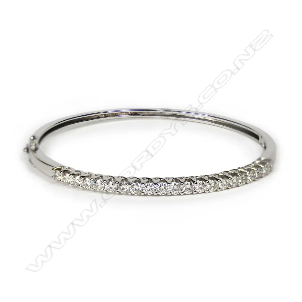 An 18ct white gold and diamond set half hinged bangle, the top with 21 round brilliant cut diamonds of TDW. 2.07ct secured in curved cross-over design settings. Graded H-I and SI-I1. 11.90gms. Valuation available. Image 1++