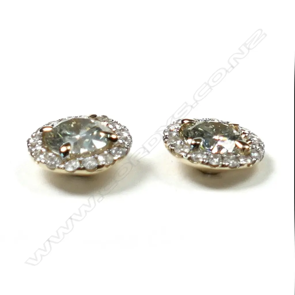 A pair of 14ct gold diamond halo stud earrings, each earring set with a 0.58ct round brilliant cut diamonds (M-N colour, SI2-I1 clarity), claw set and surrounded by sixteen round brilliant cut diamonds (J-K colour, SI1-I2 clarity), posts for pierced ears, TDW 1.33ct. Image 1++