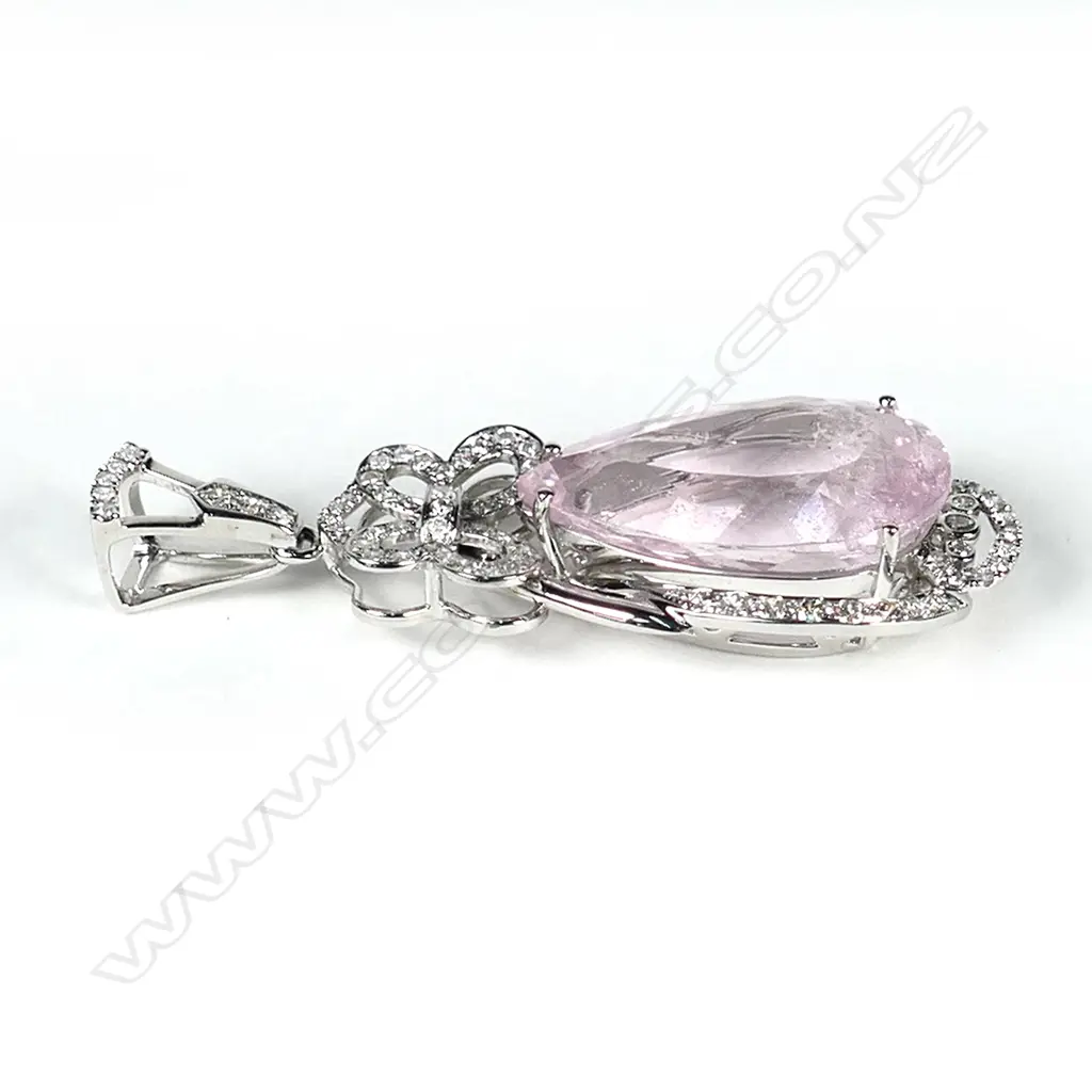 An impressive 14ct white gold morganite and diamond pendant, a 17.74ct pear cut medium pink morganite (visible inclusions), claw set and surrounded by a semi halo of round brilliant cut diamonds with a diamond encrusted bow to the top, suspended from a diamond set bale (J-L/champagne colour, SI1-I1 clarity), TDW 0.81ct. Image 1++