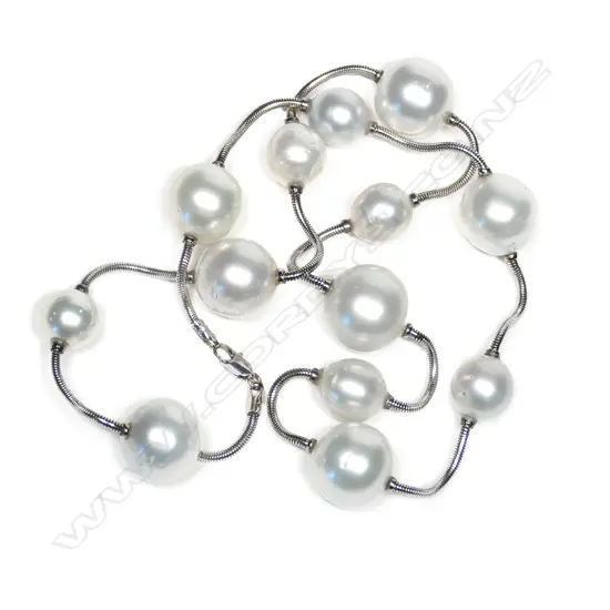 An 18ct white gold and South Sea pearl necklace, thirteen 10.38mm - 15mm white South Sea cultured pearls joined by a snake link chain with parrot clasp. L.520mm.  Valuation available.