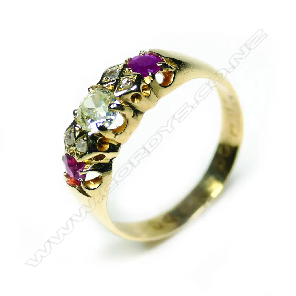 An late 19thC 18ct gold ruby and diamond ring, the central large diamond flanked by diamond enhancers and two facet cut rubies. One chipped. Image 1++