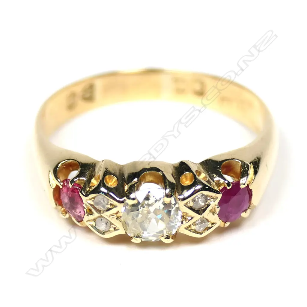 An late 19thC 18ct gold ruby and diamond ring, the central large diamond flanked by diamond enhancers and two facet cut rubies. One chipped. Image 1++