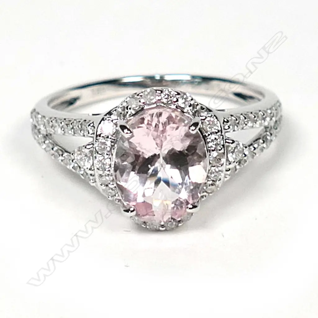 A 14ct white gold morganite and diamond vintage style halo ring, a 1.74ct oval cut light purplish pink morganite (eye clean clarity), claw set and surrounded by round brilliant cut diamonds with further diamonds set to the split shoulders, (G-H colour, SI2-I2 clarity), TDW 0.34ct, ring size M. Image 1++
