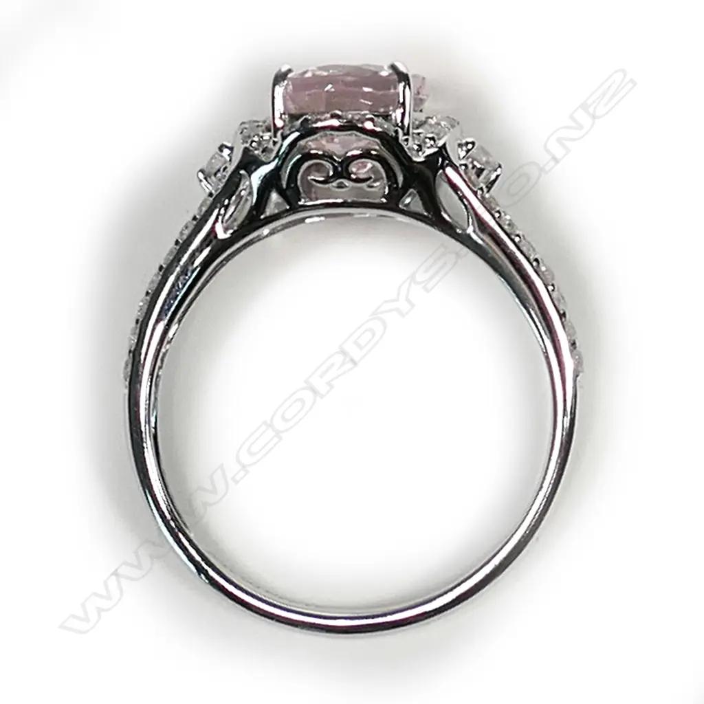 A 14ct white gold morganite and diamond vintage style halo ring, a 1.74ct oval cut light purplish pink morganite (eye clean clarity), claw set and surrounded by round brilliant cut diamonds with further diamonds set to the split shoulders, (G-H colour, SI2-I2 clarity), TDW 0.34ct, ring size M. Image 1++