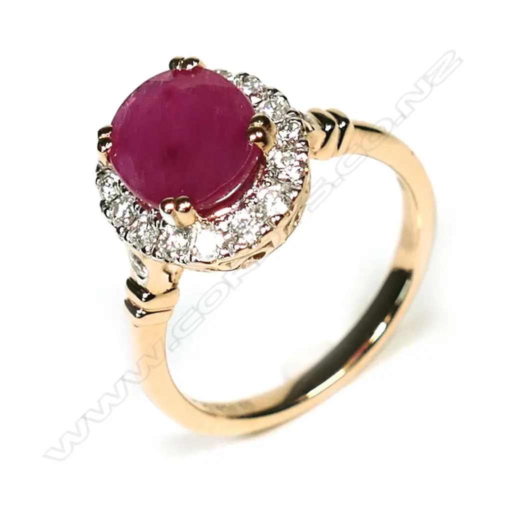 A 14ct rose gold ruby and diamond halo ring, a 2.35ct oval cut red ruby claw set and surrounded by round brilliant cut diamonds (I-J colour, SI1-I2 clarity), with a further brilliant cut diamond to each shoulder, (I-J colour, SI1-SI2 clarity), TDW 0.42ct ring size O. Image 1++