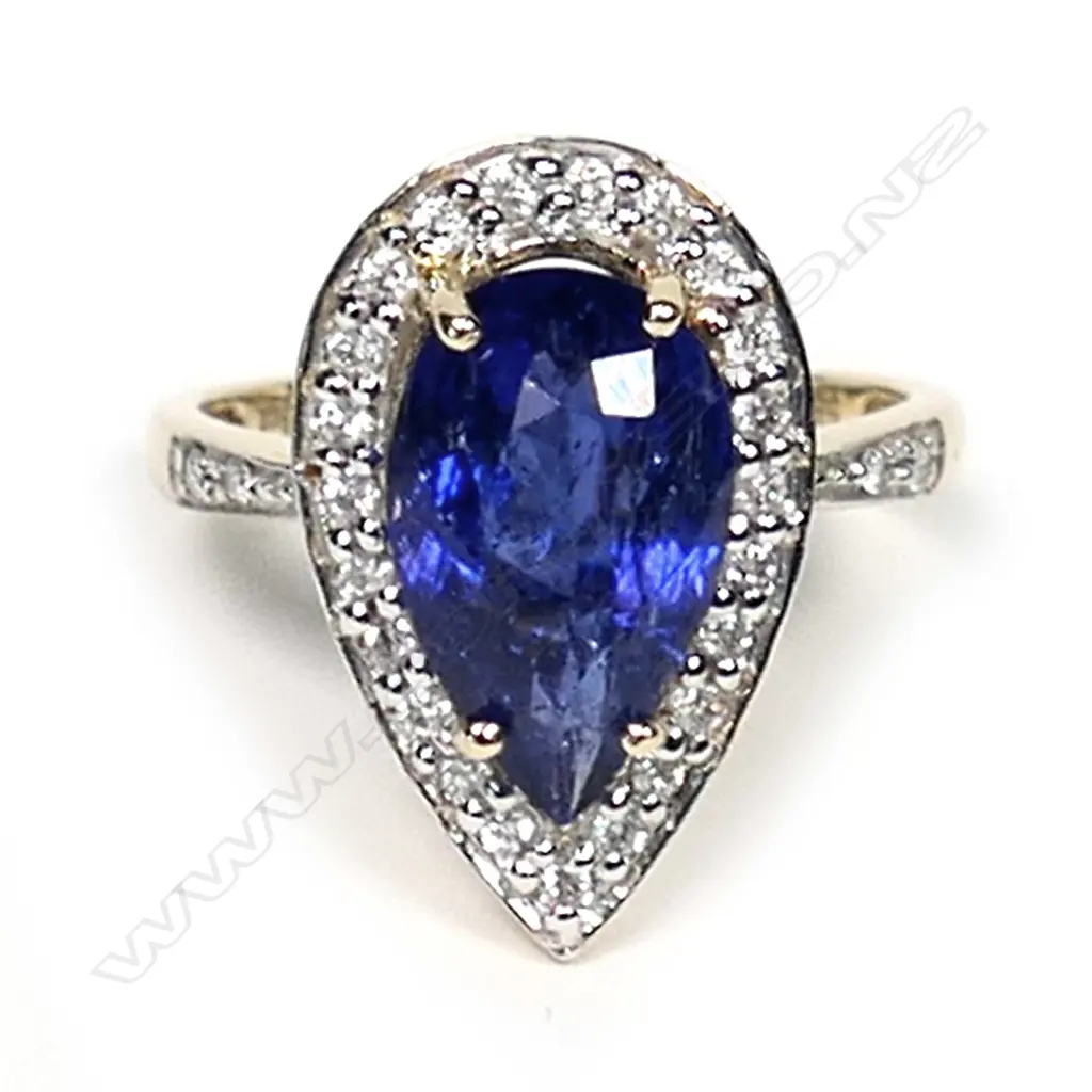 A 14ct gold tanzanite and diamond antique style halo ring, a 3.22ct pear faceted cut vivid violet blue tanzanite (moderate-heavy inclusions), claw set and surrounded by round brilliant cut diamonds with further diamonds to the band, (G-I colour, SI-I2 clarity) TDW 0.23ct, ring size N. Image 1++