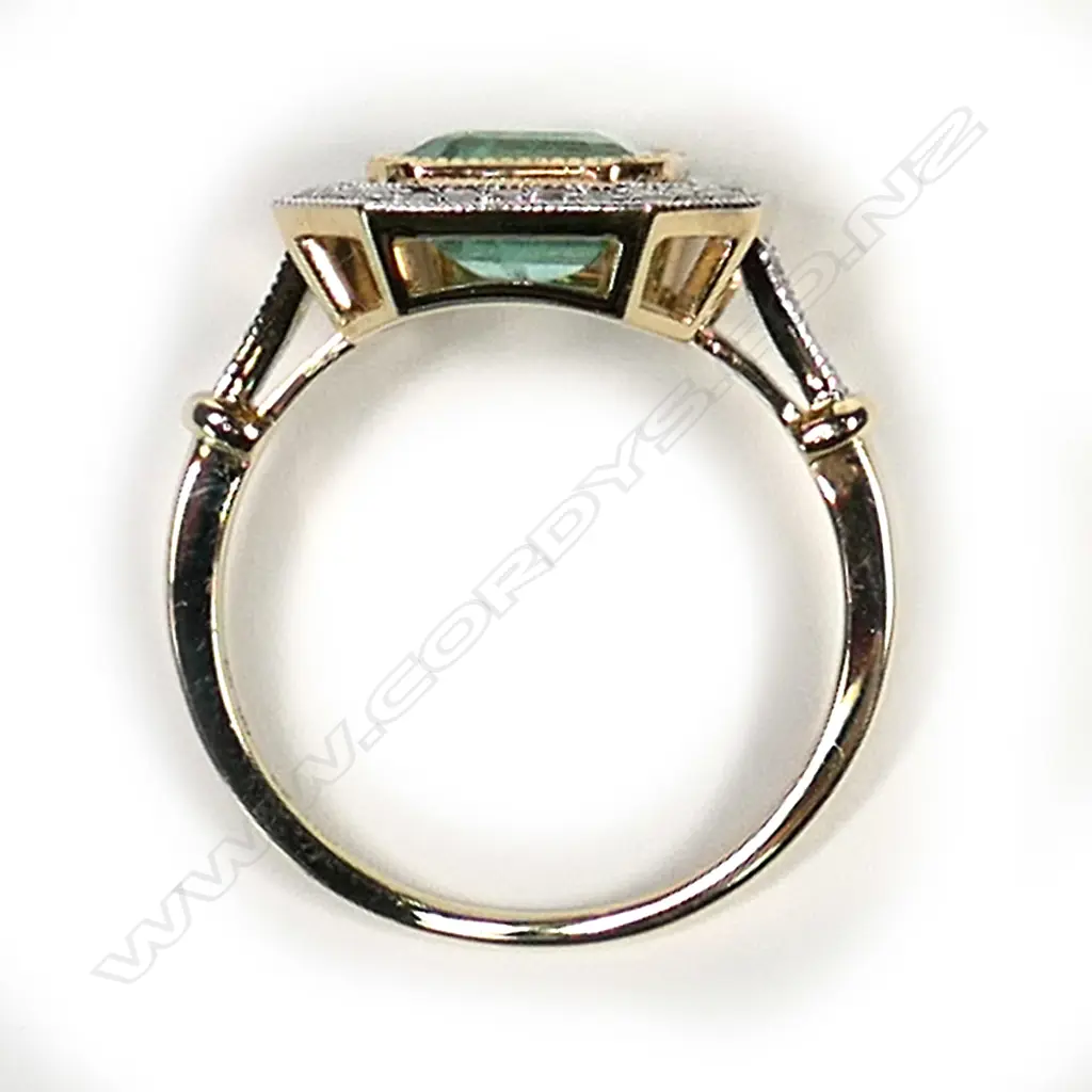 a 14ct gold Columbian emerald and diamond, antique style ring, a 1.93ct emerald cut, bluish-green Columbian emerald (minor eye visible inclusions), bezel set and surrounded by a halo of round brilliant cut diamonds with further diamonds to the shoulders, (G-H colour, SI1-I1 clarity), TDW 0.24ct ring size M. Image 1++