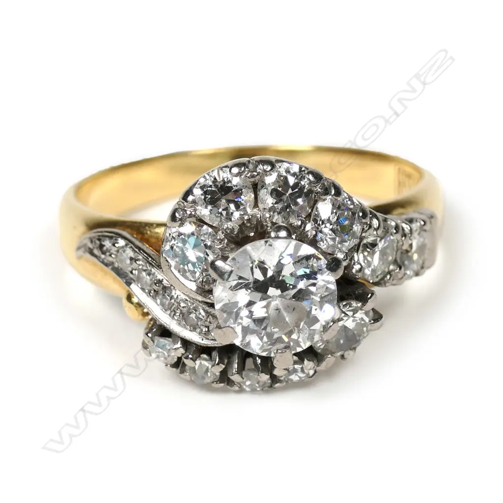 An 18ct gold, diamond solitaire cross-over ring, the central 0.82ct early round brilliant cut graded I-J and I1, framed by 17 further diamonds. TDW 1.93ct. Valuation available. Image 1++