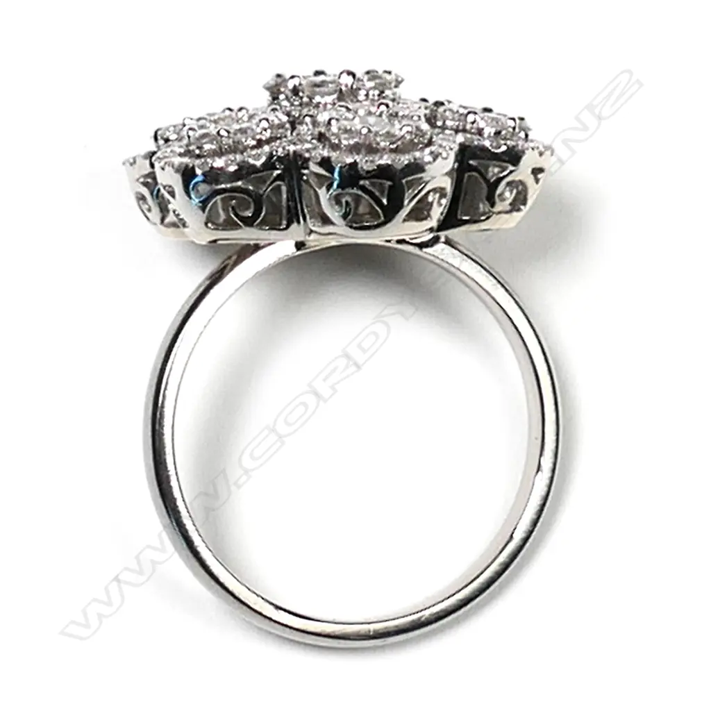 An 18ct white gold and diamond cluster ring, a central cluster of modern round brilliant cut diamonds surrounded by six small clusters of modern round brilliant cut diamonds, set in a decoratively pierced mount, TDW 1.80ct.  Valuation available. Image 1++