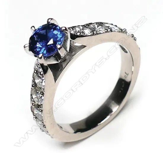 An 18ct white gold sapphire and diamond ring, the 1.17ct oval mixed cut violet blue sapphire claw set with six round modern brilliant diamonds set to each upswept shoulder, TDW 1.22ct.  Valuation available.