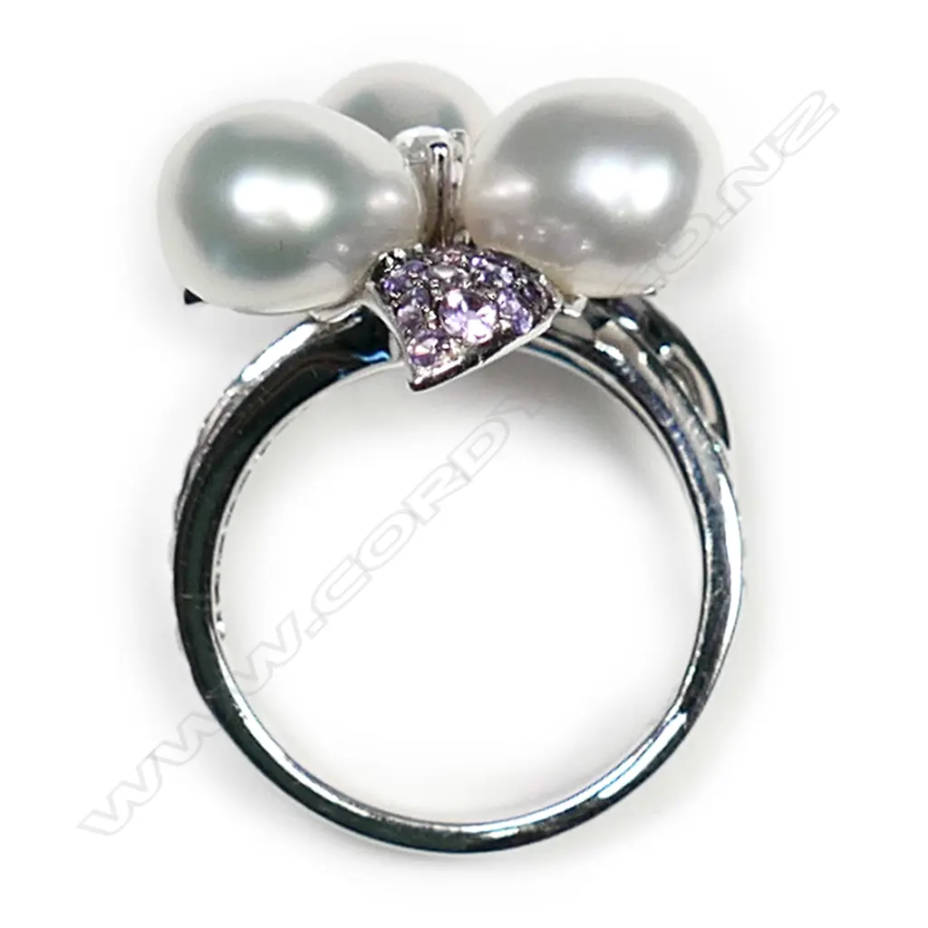 A 18ct white gold Autore purple sapphire pearl and diamond ring, three Autore pearls set to the centre of a diamond and sapphire set floral mount, with further diamonds set to the split shoulders, TDW 0.55ct, TSW 1.40ct.  Valuation available. Image 1++