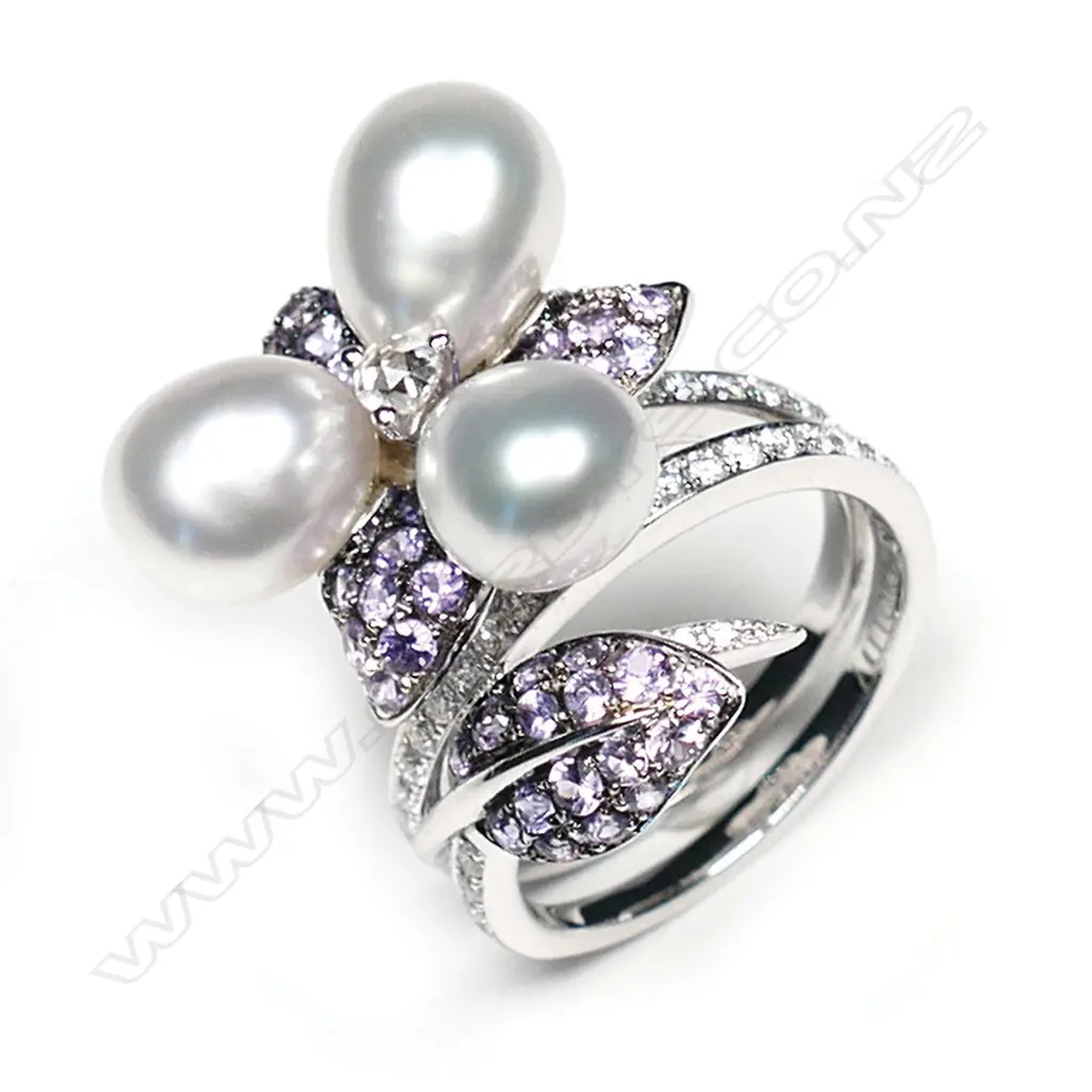 A 18ct white gold Autore purple sapphire pearl and diamond ring, three Autore pearls set to the centre of a diamond and sapphire set floral mount, with further diamonds set to the split shoulders, TDW 0.55ct, TSW 1.40ct.  Valuation available. Image 1++