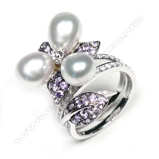 A 18ct white gold Autore purple sapphire pearl and diamond ring, three Autore pearls set to the centre of a diamond and sapphire set floral mount, with further diamonds set to the split shoulders, TDW 0.55ct, TSW 1.40ct.  Valuation available.