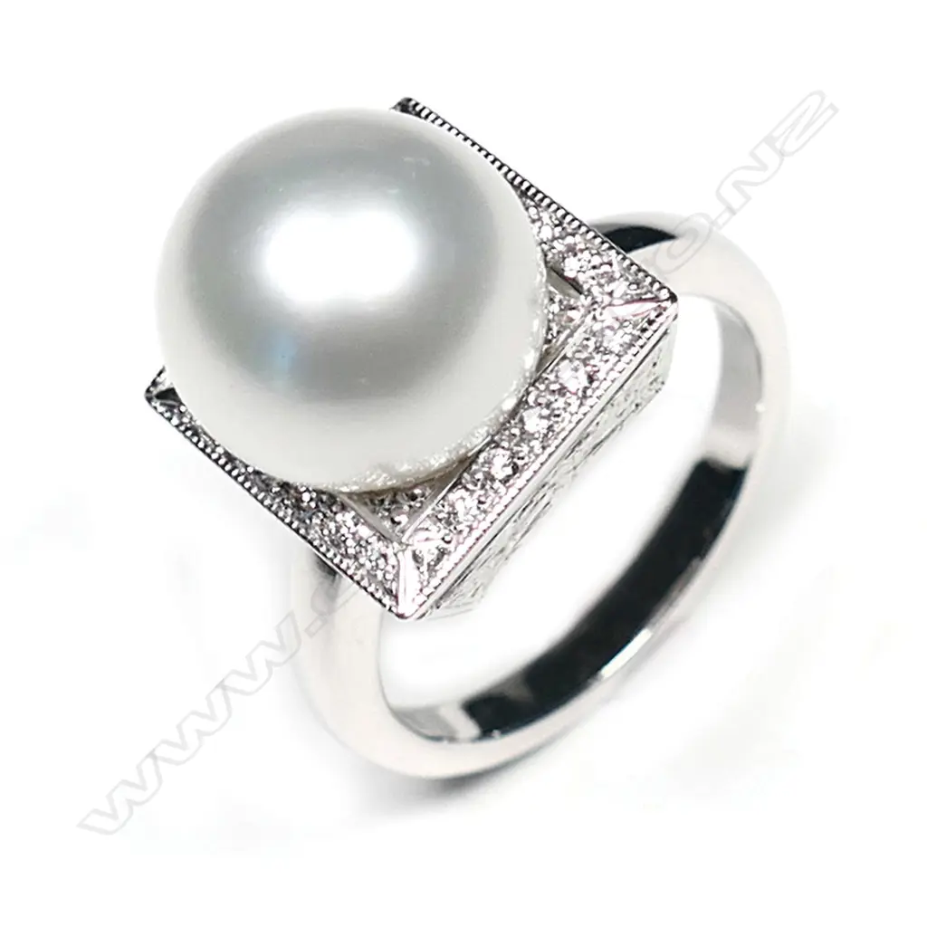 An 18ct white gold and pearl Art Deco style ring, a 11.83mm South Sea cultured pearl set to the centre of square diamond set mount with engraved decoration to each side, TDW 0.20ct.  Valuation available. Image 1++