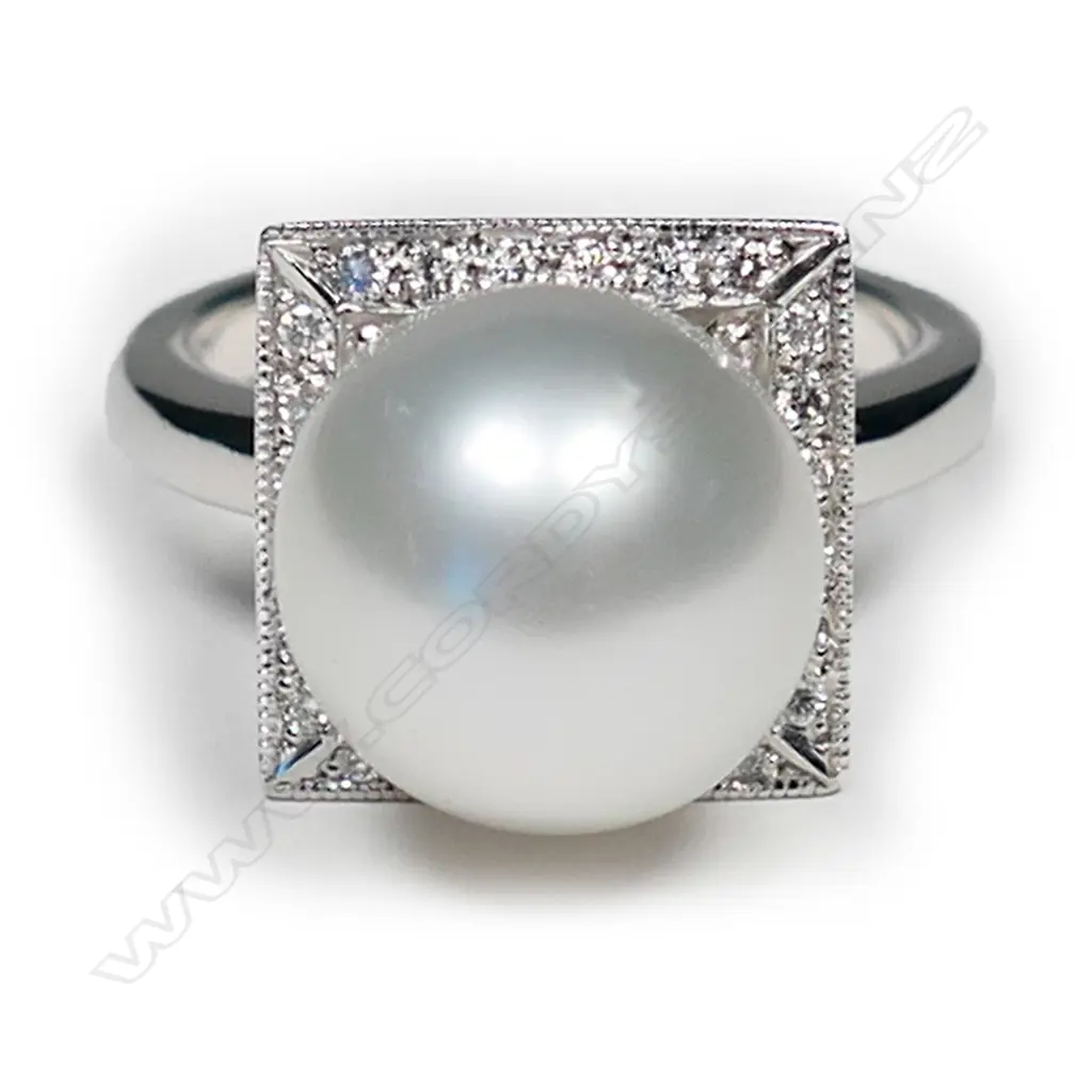 An 18ct white gold and pearl Art Deco style ring, a 11.83mm South Sea cultured pearl set to the centre of square diamond set mount with engraved decoration to each side, TDW 0.20ct.  Valuation available. Image 1++