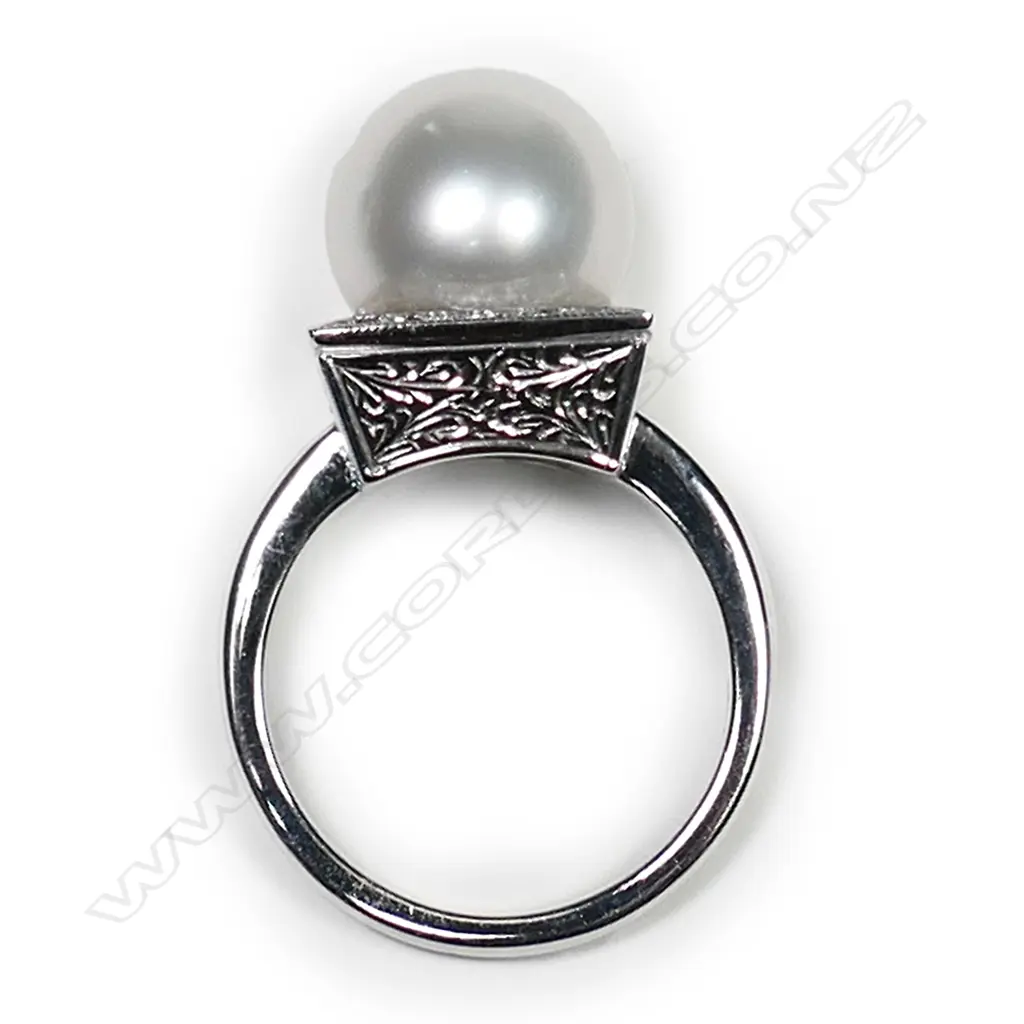 An 18ct white gold and pearl Art Deco style ring, a 11.83mm South Sea cultured pearl set to the centre of square diamond set mount with engraved decoration to each side, TDW 0.20ct.  Valuation available. Image 1++