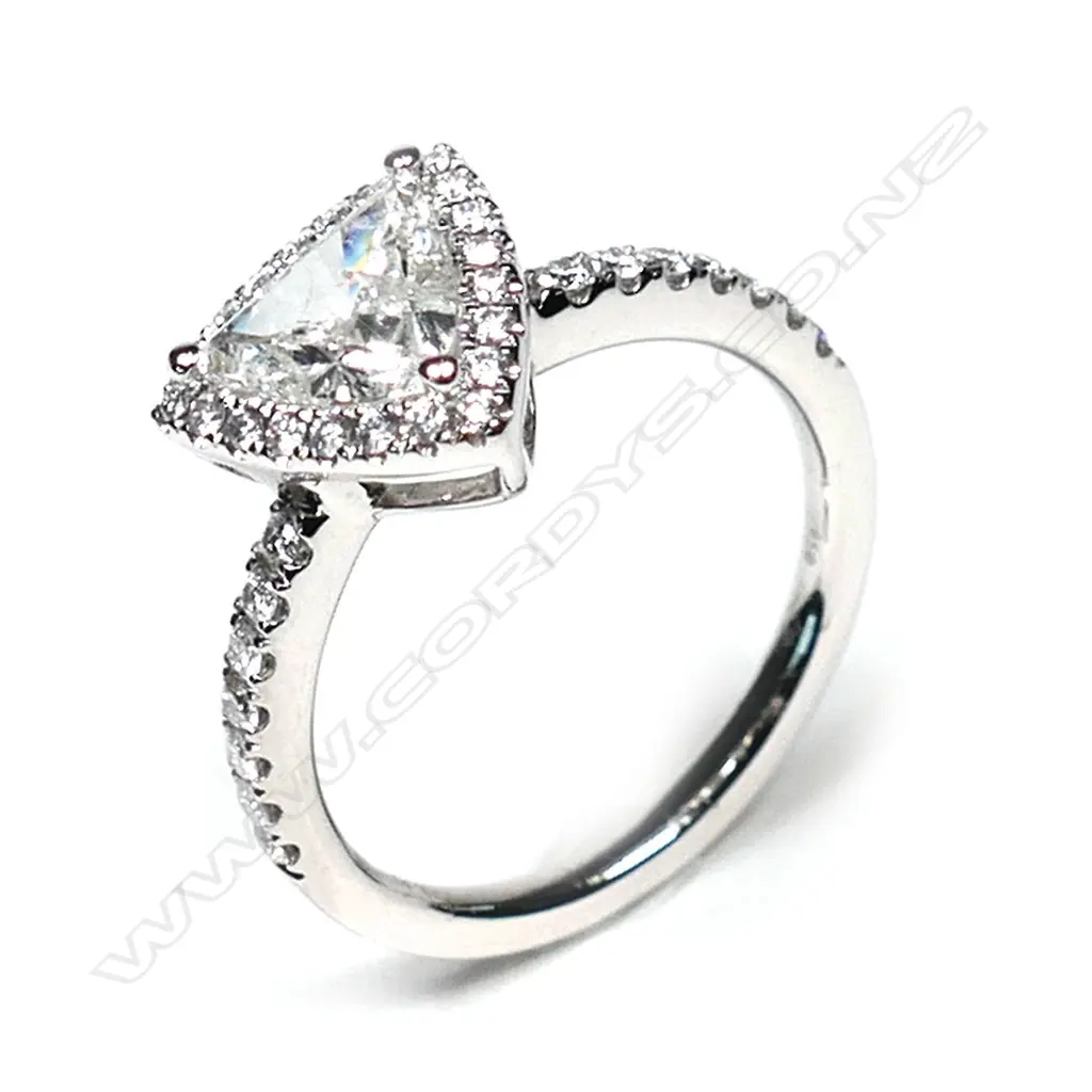 A platinum and diamond vintage style halo ring, a 0.92ct trillion cut diamond (J-K colour, I1-I2 clarity), claw set and surrounded by a halo of twenty-one round brilliant cut diamonds (I-K colour, SI1-I2 clarity), with another fourteen round brilliant cut diamonds set to the band (I-K colour, SI1-I2 clarity), TDW 0.33ct ring size M. Image 1++