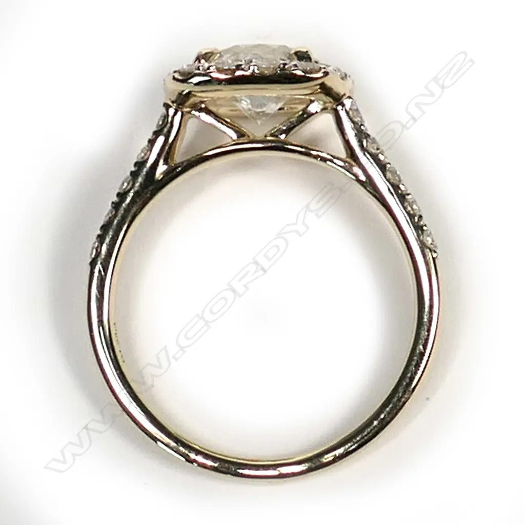 A 14ct gold diamond vintage style halo ring. a 0.73ct round brilliant cut diamond (M-N colour, I1-I2 clarity), claw set and surrounded by a halo of fourteen round brilliant cut diamonds (, I-K colour, SI1-I2 clarity), with a further five diamonds to each shoulder, (I-K colour, SI1-I2 clarity), TDW 1.23ct, ring size I 1/2. Image 1++