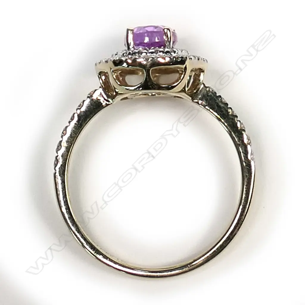 A 14ct gold pink sapphire and diamond double halo ring, a 1.38ct oval cut deep pink sapphire (slightly included), claw set and surrounded by a double halo of round brilliant cut champagne Diamonds (SI1-P2 clarity), with a further six round brilliant cut champagne diamonds to each shoulder, (SI1-P2 clarity), TDW 0.43ct ring size L½. Image 1++