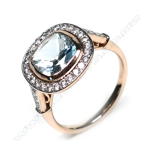 A 14ct rose gold aquamarine and diamond ring, a 1.75ct square cushion cut greyish-blue aquamarine (eye clean clarity), bezel set and surrounded by a halo of twenty-six round brilliant cut diamonds with a further three diamonds to each shoulder, (H-J colour, SI2-I2 clarity), TDW 0.43ct ring size N.