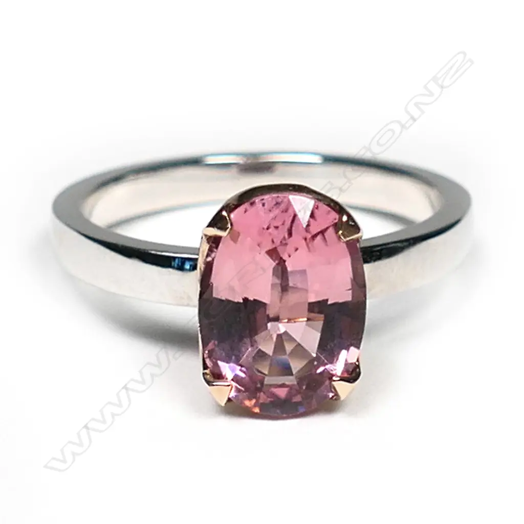 An 18ct white and yellow gold pink tourmaline ring, the 2.25ct oval mixed cut pink tourmaline claw set in yellow gold on a plain white gold band.  Valuation available. Image 1++