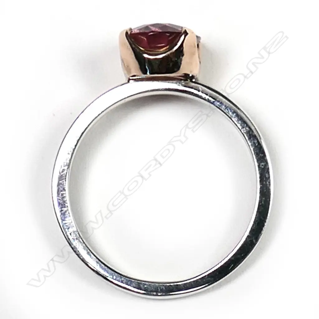 An 18ct white and yellow gold pink tourmaline ring, the 2.25ct oval mixed cut pink tourmaline claw set in yellow gold on a plain white gold band.  Valuation available. Image 1++