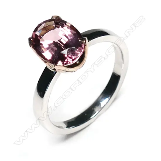 An 18ct white and yellow gold pink tourmaline ring, the 2.25ct oval mixed cut pink tourmaline claw set in yellow gold on a plain white gold band.  Valuation available.