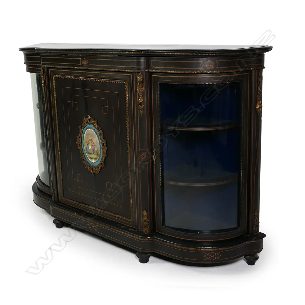 A Victorian ebonised credenza, decorative stringing with ormolu embellishments, shaped doors to the sides, the front with a Sevres style plaque to the centre, raised on plinth base and squat bun feet. 1680 x 420 x 1080mm. Image 1++
