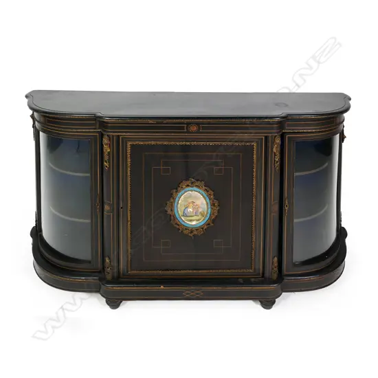 A Victorian ebonised credenza, decorative stringing with ormolu embellishments, shaped doors to the sides, the front with a Sevres style plaque to the centre, raised on plinth base and squat bun feet. 1680 x 420 x 1080mm.