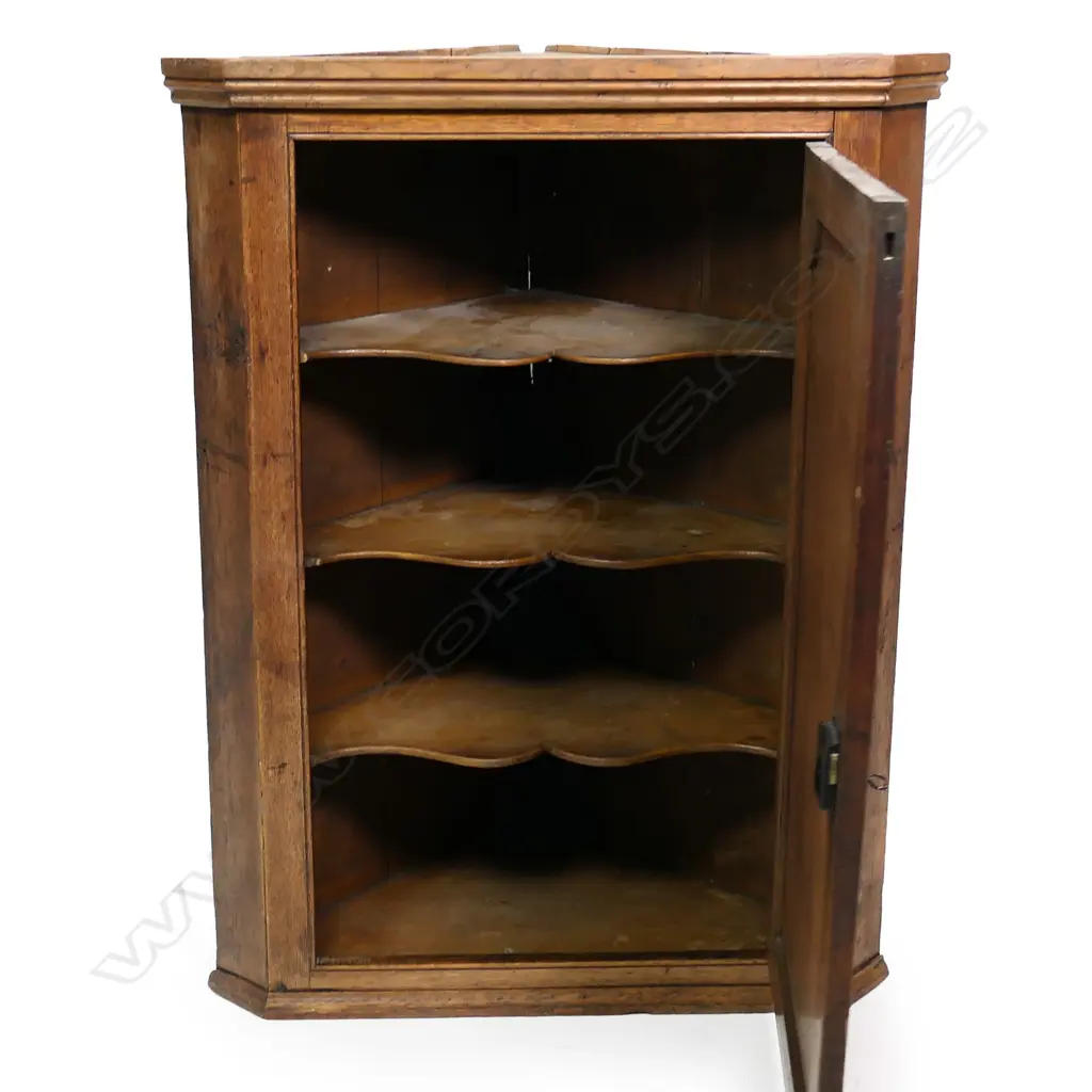 A late Georgian corner cabinet, inlaid panel to door, the interior with three scalloped shelves.  780 x 470 x 1065mm. Image 1++