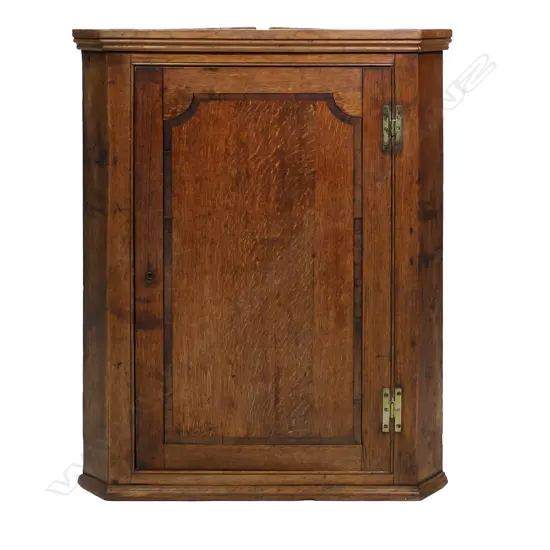 A late Georgian corner cabinet, inlaid panel to door, the interior with three scalloped shelves.  780 x 470 x 1065mm.
