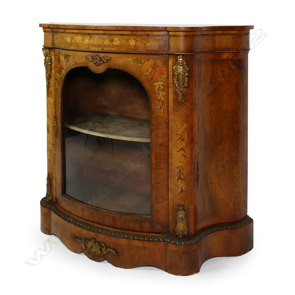 A Victorian walnut pier cabinet, curved sides, inlaid decoration and ormolu embellishments, two velvet lined shelves to the interior, slightly curved glass to the door, raised on plinth base.  1130 x 450 x 1170mm. Image 1++