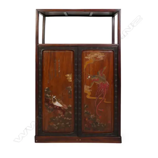 A vintage Chinese rosewood display shelf cupboard, the plain raised top shelf above a pair of tall cupboard doors with carved and painted phoenix, clouds, florals and calligraphy, enclosing three shelves and two drawers. 910 x 440 x 1515mm.