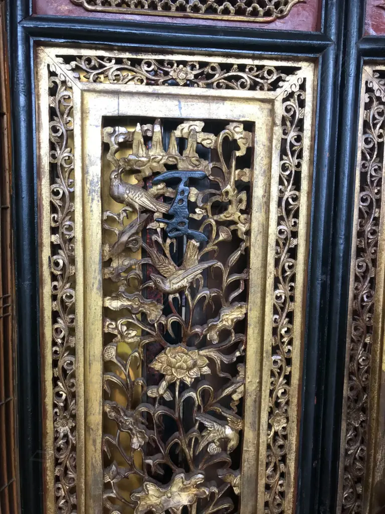 A 19thC six-fold Chinese screen, each panel with pierced decoration of calligraphy, birds and flowering branches, gilded with black and red paint finish, each panel measures 400 x 2050mm. Image 1++