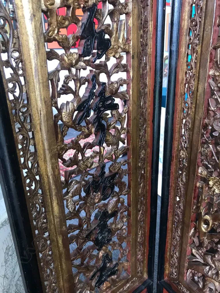 A 19thC six-fold Chinese screen, each panel with pierced decoration of calligraphy, birds and flowering branches, gilded with black and red paint finish, each panel measures 400 x 2050mm. Image 1++