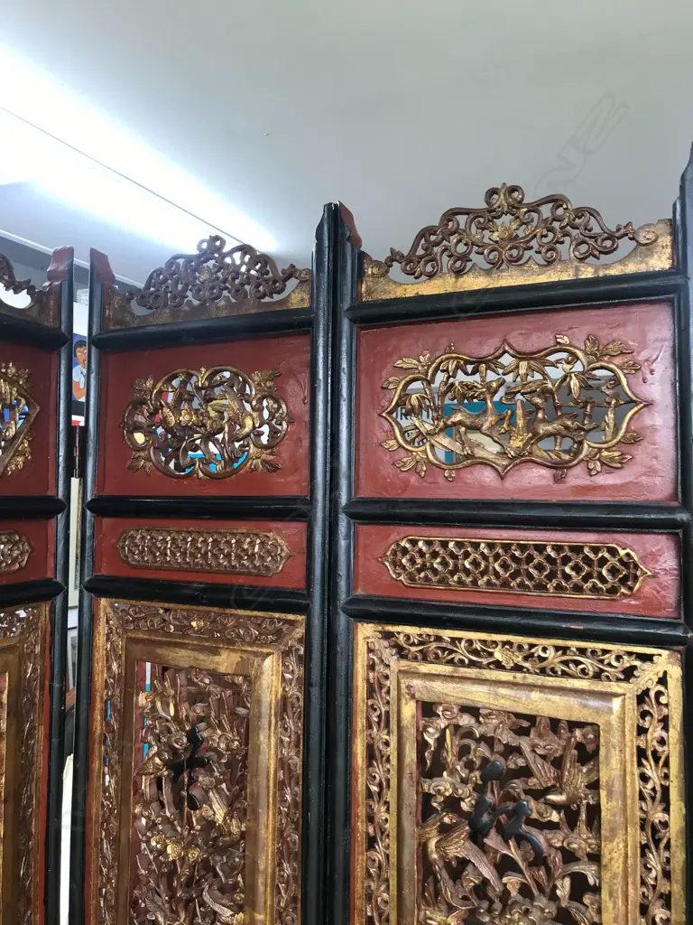 A 19thC six-fold Chinese screen, each panel with pierced decoration of calligraphy, birds and flowering branches, gilded with black and red paint finish, each panel measures 400 x 2050mm. Image 1++
