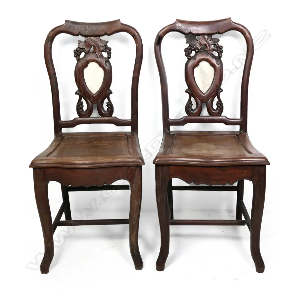 A pair of vintage Chinese rosewood side chairs, the shield back panels set with marble inserts and framed by grape bunch and leaf carving with scroll supports, panelled seats, stretched legs. Image 1++