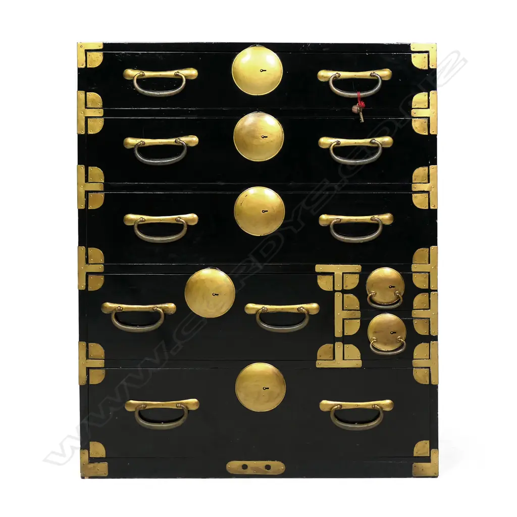A c1900 Japanese issho-dansu clothing chest, black lacquered with gilt metal handles, large disc lock plates and fittings, a combination of seven drawers, with key. From the Gifu prefecture. 850 x 400 x 1650mm. Image 1++