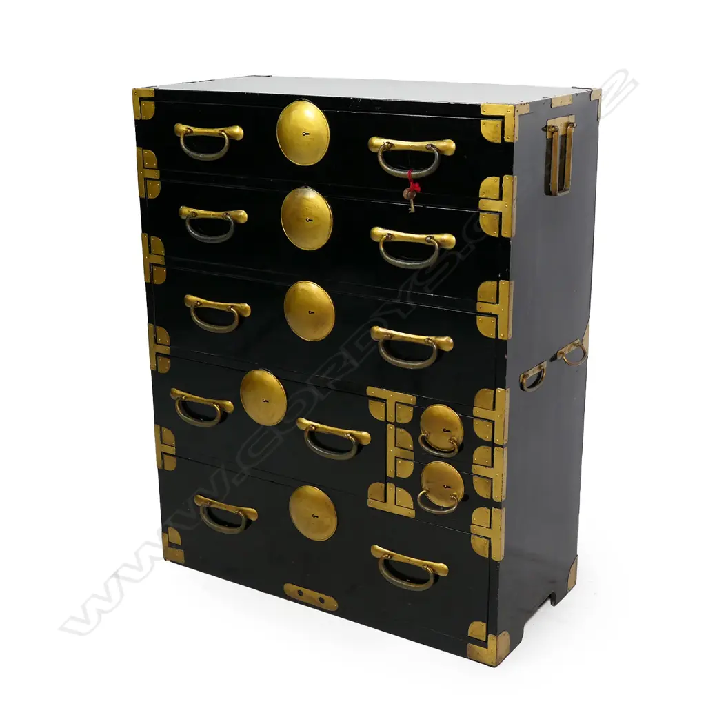 A c1900 Japanese issho-dansu clothing chest, black lacquered with gilt metal handles, large disc lock plates and fittings, a combination of seven drawers, with key. From the Gifu prefecture. 850 x 400 x 1650mm. Image 1++