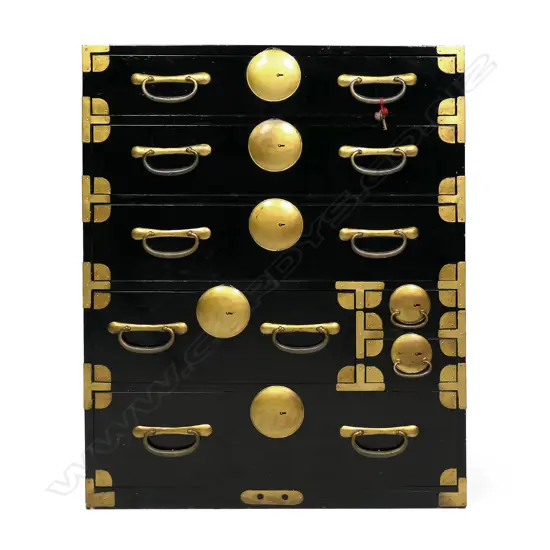 A c1900 Japanese issho-dansu clothing chest, black lacquered with gilt metal handles, large disc lock plates and fittings, a combination of seven drawers, with key. From the Gifu prefecture. 850 x 400 x 1650mm.