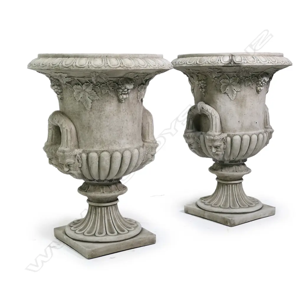 A pair of quality English made cast concrete classical garden urns, Regency style with ogee and dart flared top rims, grape leave and bunch detail below, the looping handles with mask supports. The lobed pedestals with square bases. Dia.530mm. H.710mm. Image 1++