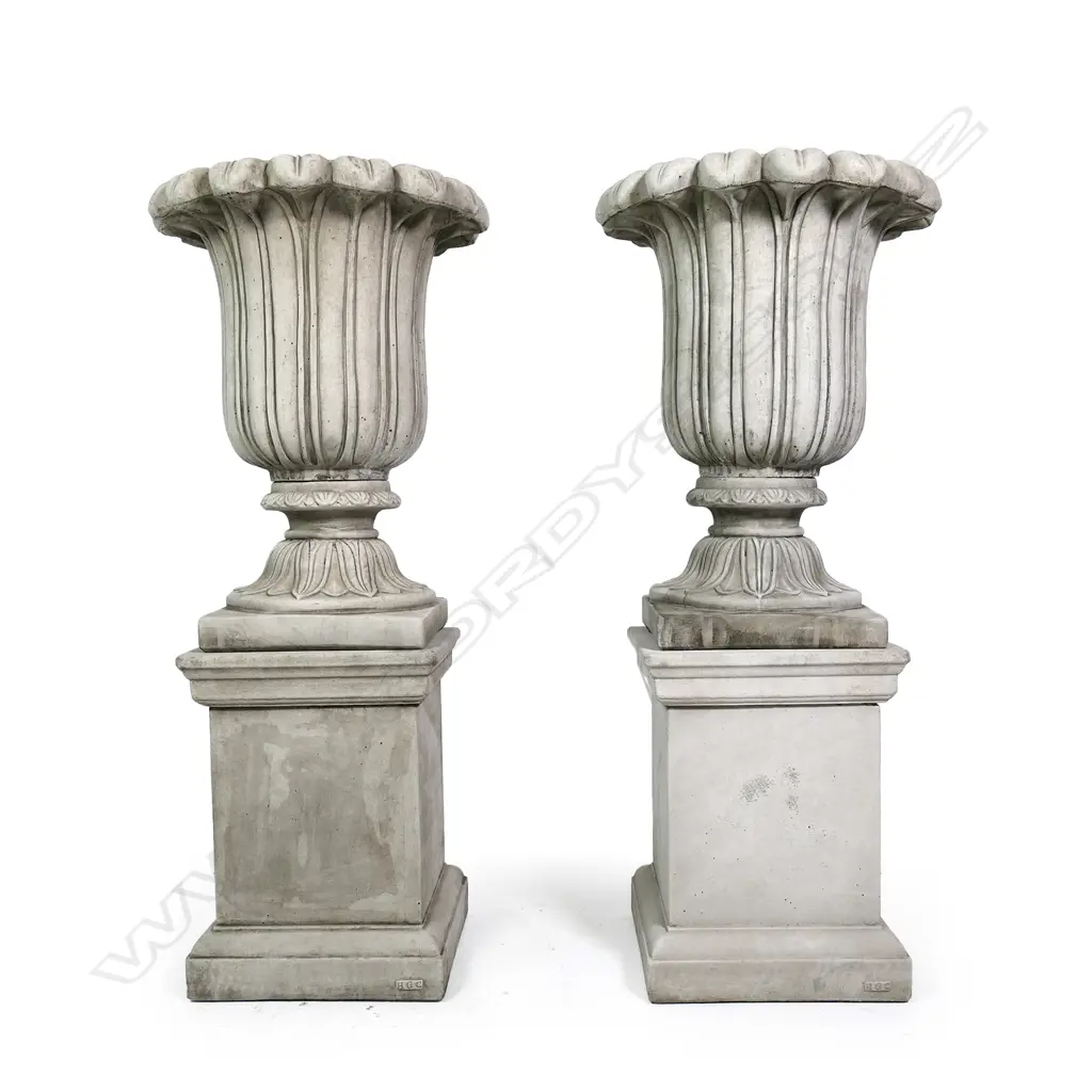 A pair of quality English made cast concrete classical garden urns raised on plinths, vertical fluted detail with swollen leafy flared top rims, the plinths of plain square form. H.1180mm. Image 1++