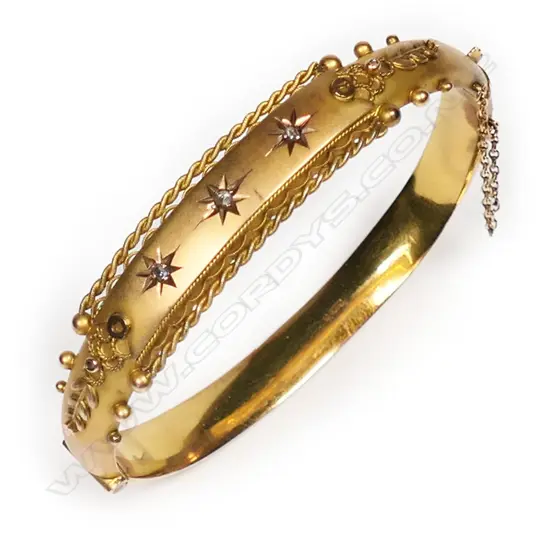 An early 20thC 9ct yellow gold and diamond snap bangle.