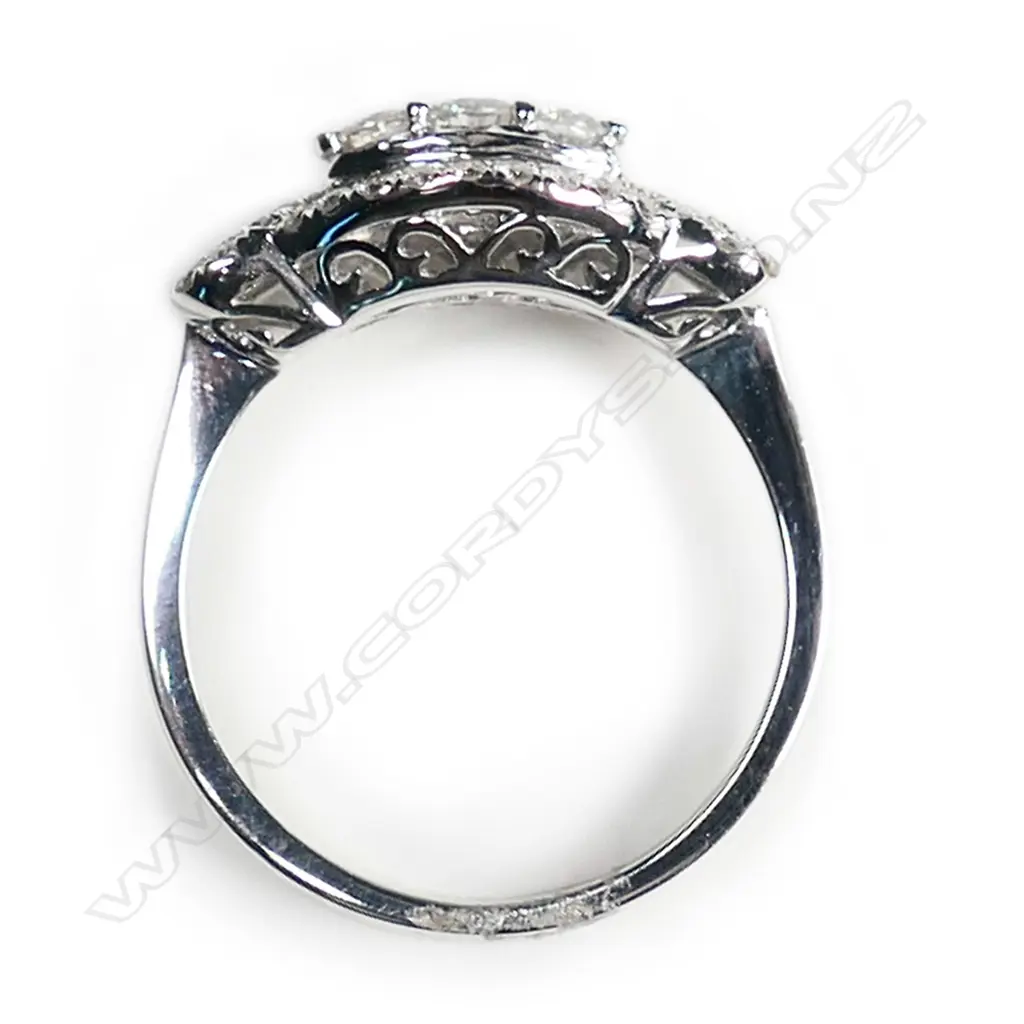 An 18ct white gold and multi diamond ring, formed as twin hearts flanking an oval section set with 53 brilliant and 13 tapered baguette cuts of TDW 1.02ct. Image 1++