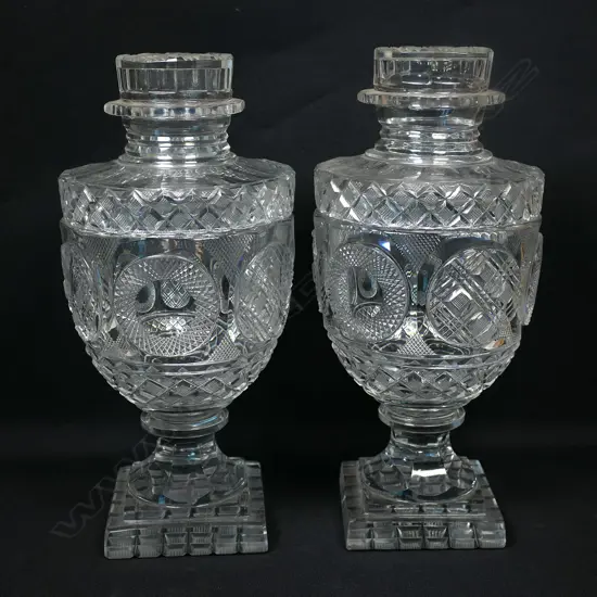 A pair of good quality cut glass lidded urns of Georgian style