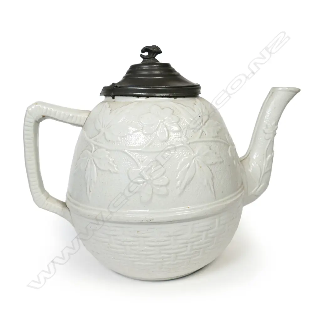 A salt glaze china Victorian period teapot, with pewter mounted cover and decorated with prunus and basket weave. Unmarked. W.230mm. Image 1++