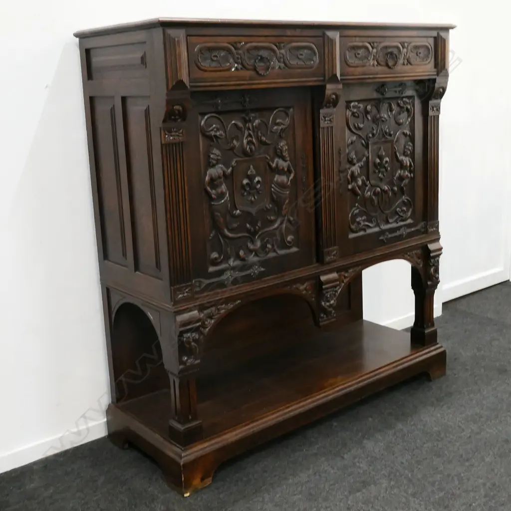 A 19thC oak Continental sideboard, two half drawers over two elaborately carved doors, shelf to base with conforming carved detail. 1280 x 500 x 1400mm. Image 1++