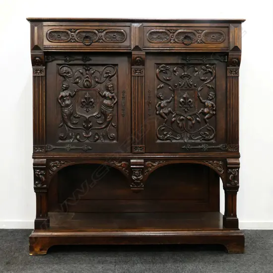 A 19thC oak Continental sideboard, two half drawers over two elaborately carved doors, shelf to base with conforming carved detail. 1280 x 500 x 1400mm.