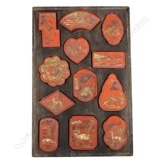 A Chinese hardwood boxed set of twelve Zodiac sign red ink stones,